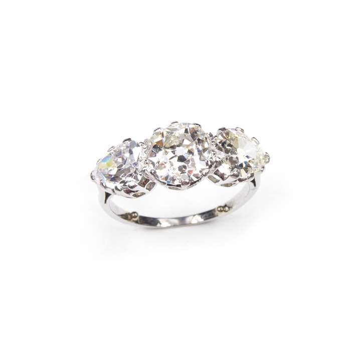 Art Deco three stone diamond ring, claw set with a central cushion cut diamond between pear shaped diamonds